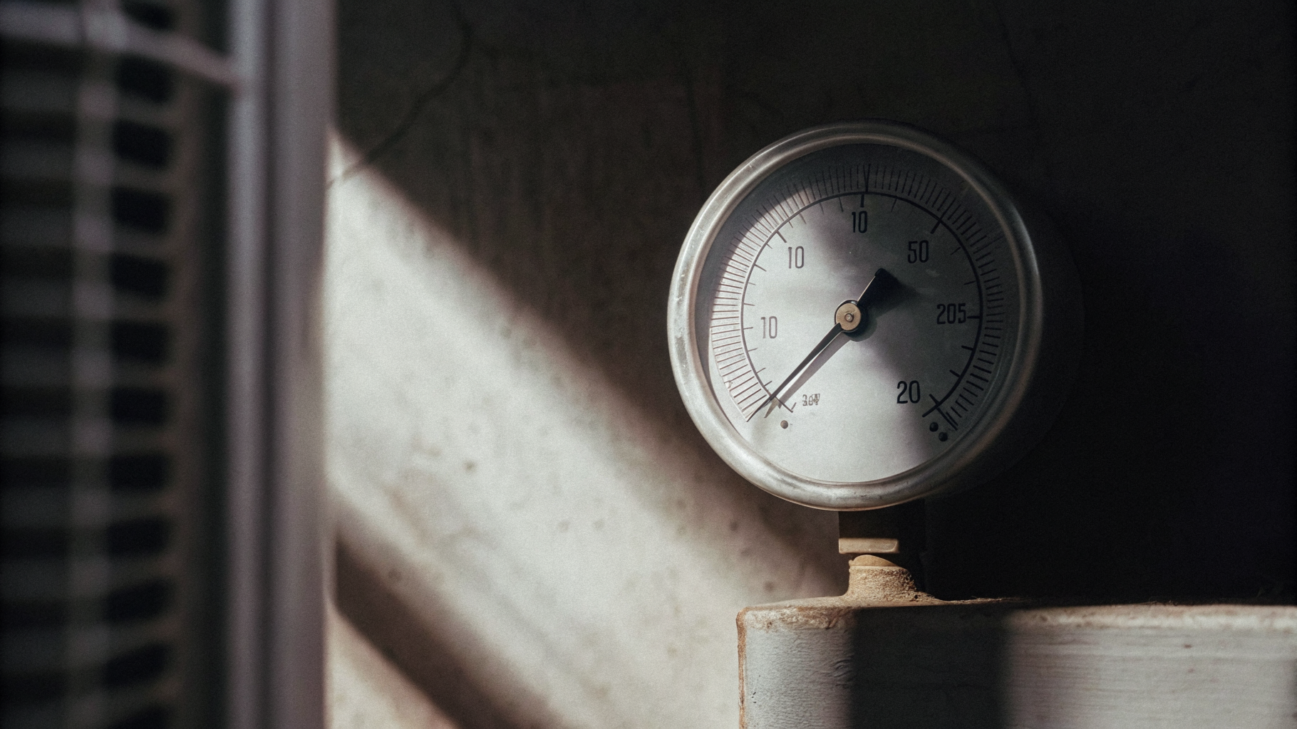 Editorial photograph of a single clear instrument reading against a plain wall