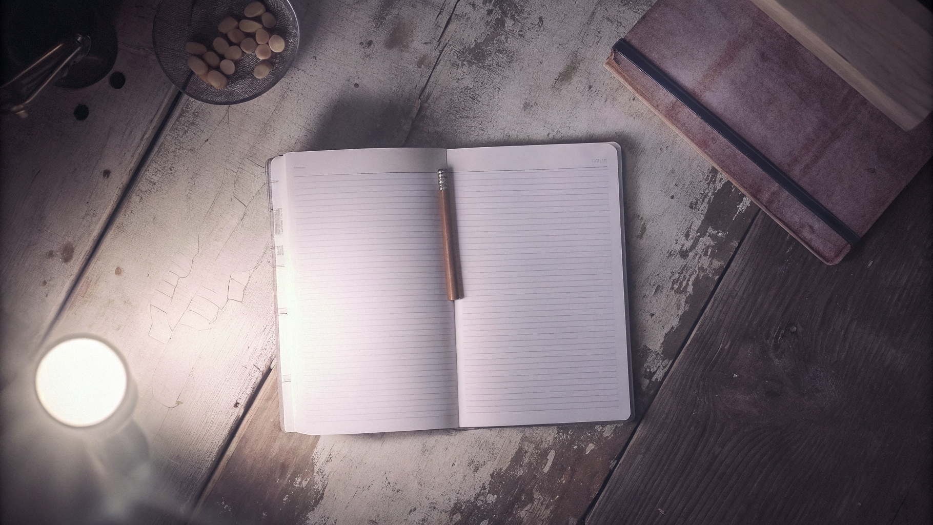 Editorial photograph of a single open notebook on a bare worktable