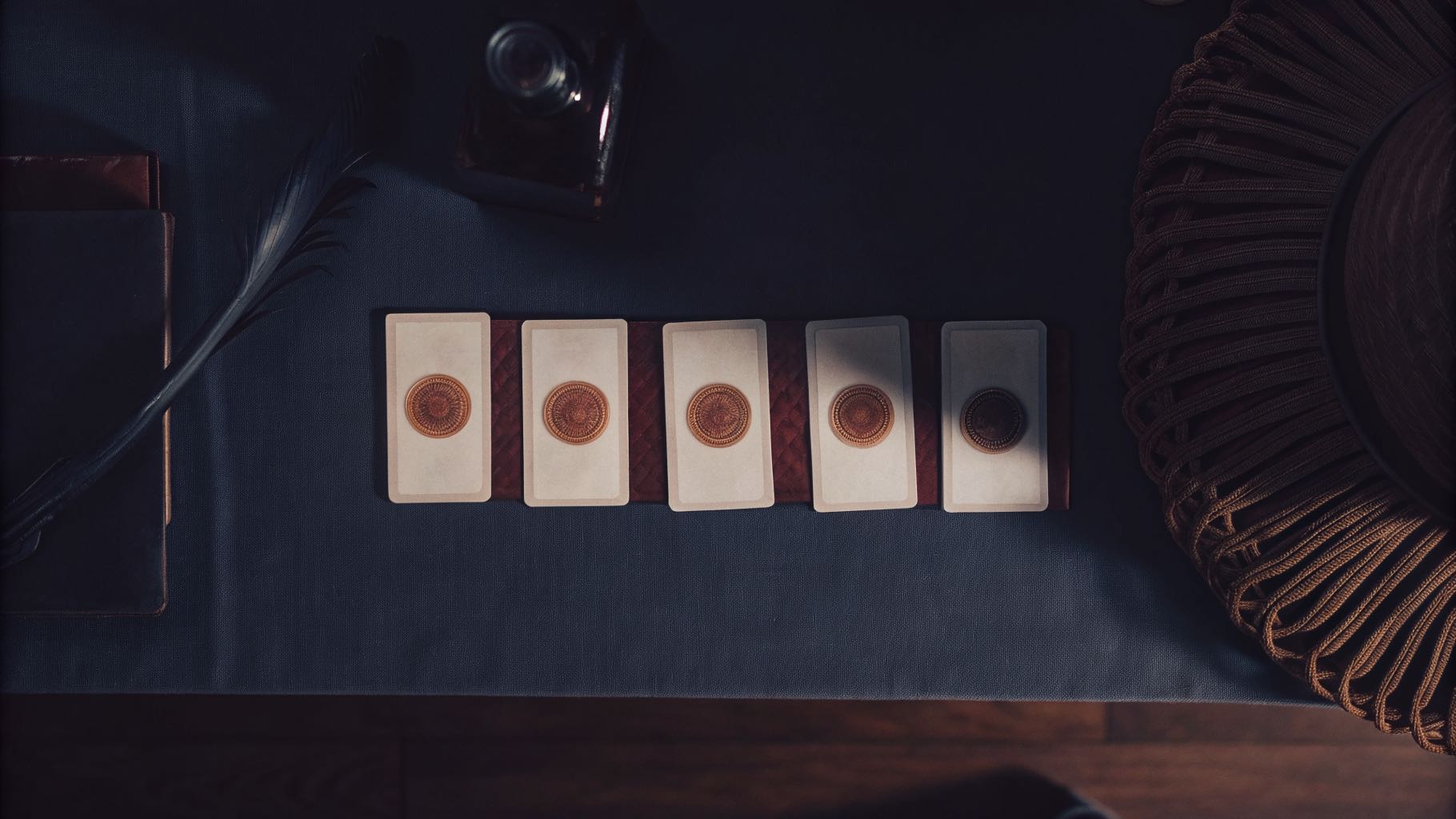 A row of letterpress cards showing one emblem refined in stages from left to right